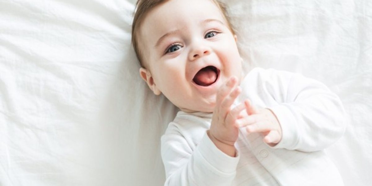 newborn-toddler-boy-laughing-bed_115594-1499